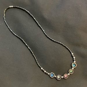 Necklace. 22 inch long with multicolored stones on a black chain.